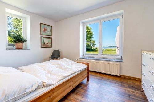 ヘリングスドルフにあるAppartementhaus am Schmollensee mit Seeblickのベッドルーム(ベッド1台、窓付)