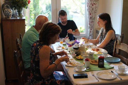 a group of people sitting around a table eating food at Villa Kakelbont Borgloon in Borgloon