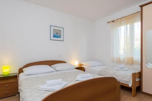 a bedroom with two beds with towels on them at Apartments Maestral in Orebić