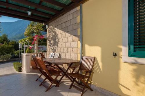 a wooden table and chairs on a patio at Apartments Maestral in Orebić