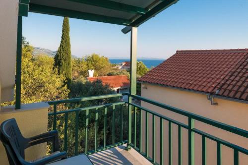 a balcony with a chair and a view of the ocean at Apartments Maestral in Orebić