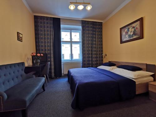 a bedroom with a bed and a couch and a window at Hotel Bajazzo in Vienna