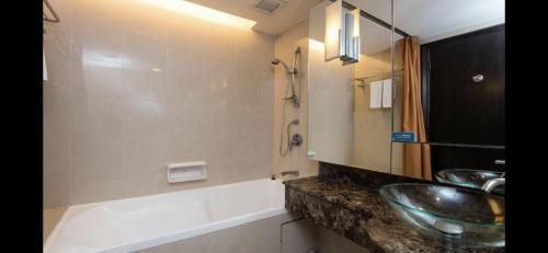 La salle de bains est pourvue de 2 lavabos, d'une baignoire et d'un lavabo. dans l'établissement Resort Suites by Landmark at Bandar Sunway Sunway Lagoon, à Kampong Penaga