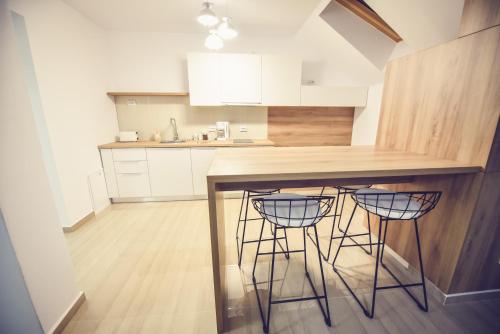 a kitchen with a counter and two bar stools at Vila Darimar Chișoda in Chişoda