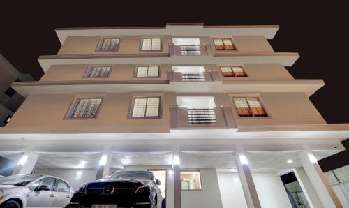 a building with two cars parked in front of it at Treebo Trend Petals Suites Ernakulam Town in Cochin