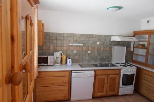 a kitchen with a sink and a stove top oven at L'Echaillon - Ancolie in Névache