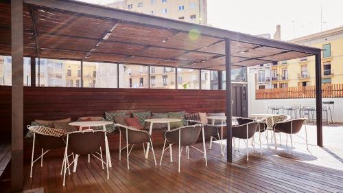a patio area with tables, chairs and umbrellas at TOC Hostel Barcelona in Barcelona