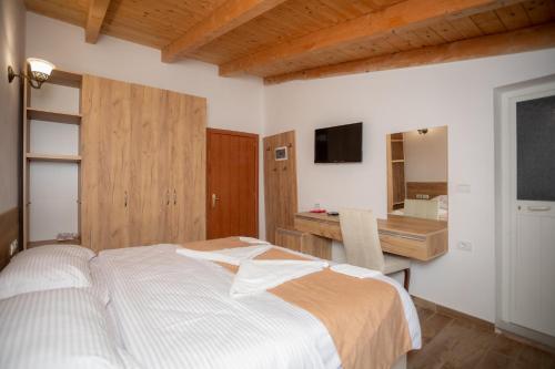 a bedroom with a bed and a desk and a television at Hotel Grandpa's House in Shkodër