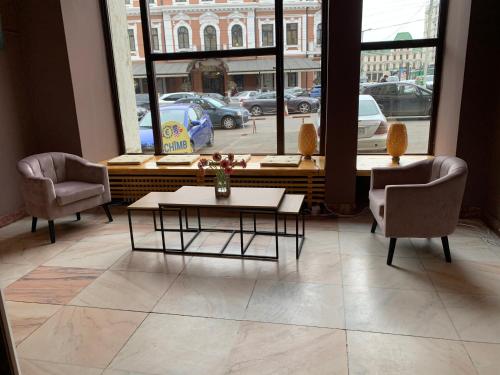 a living room with a table and two chairs and a window at Hotel Continental City Center in Iaşi