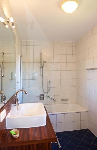 a bathroom with a sink and a bath tub at Landhaus Kössel in Füssen
