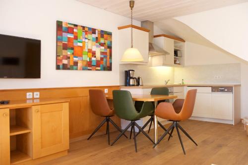 a kitchen with a table and chairs and a tv at Landhaus Kössel in Füssen