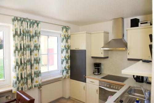 a kitchen with a window and a sink and a stove at Landhaus Kössel in Füssen