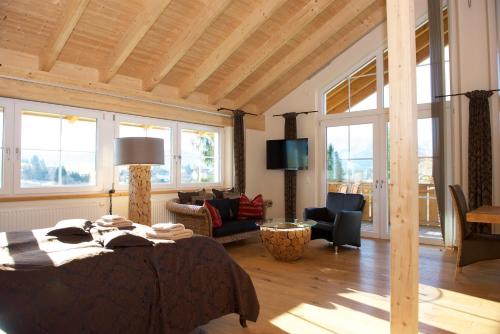 a bedroom with a bed and a living room at Landhaus Kössel in Füssen
