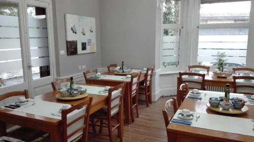 une salle à manger avec des tables et des chaises en bois ainsi que des fenêtres dans l'établissement Hotel Neguri, à Getxo
