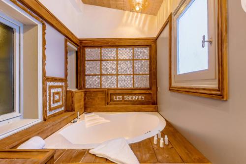 クールシュヴェルにあるHôtel Les Sherpasの窓付きの客室で、バスタブが備わります。