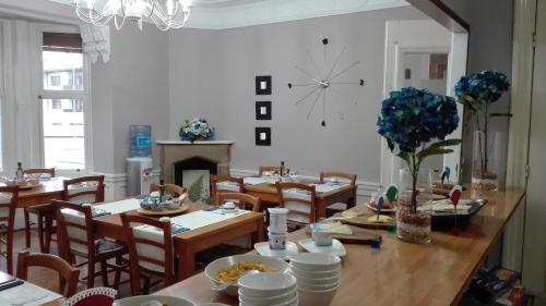 a dining room with tables and chairs and a clock on the wall at Hotel Neguri in Getxo