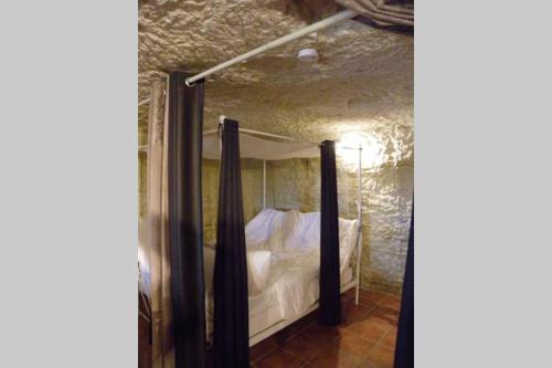 ein Schlafzimmer mit einem Bett in einem Steinzimmer in der Unterkunft Les Hauts de Nazelles in Nazelles