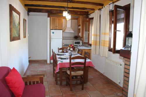 a kitchen with a table and chairs and a kitchen with a refrigerator at Apartamentos Rurales Rosendo: La Canela in Capileira