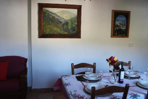 una sala da pranzo con tavolo e un dipinto sul muro di Apartamentos Rurales Rosendo: La Canela a Capileira