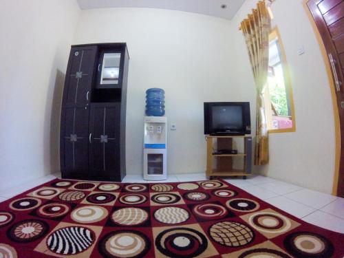 a room with a rug on the floor next to a tv at Jelajah Batukaras in Batukaras