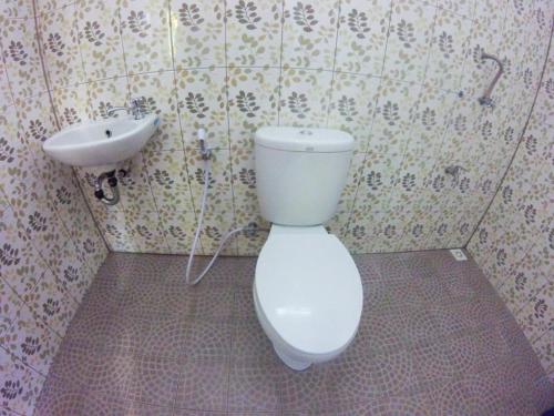 een badkamer met een wit toilet en een wastafel bij Jelajah Batukaras in Batukaras