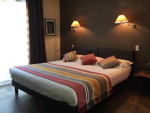 a bedroom with a large bed with pillows on it at Le Vinois in Caillac