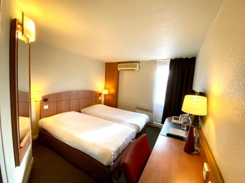 a small hotel room with a bed and a desk at Kyriad Montargis Amilly in Amilly