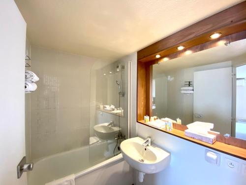 Amilly的住宿－基里亞德蒙塔基艾米麗酒店，一间带水槽和镜子的浴室