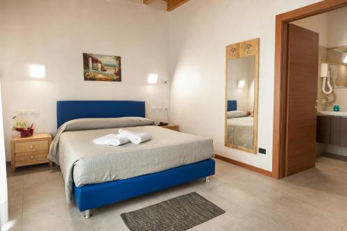 ein Schlafzimmer mit einem Bett mit zwei weißen Handtüchern darauf in der Unterkunft Agricampeggio Corte Tonolli in Valeggio sul Mincio