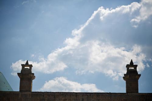 a tall tower with a clock on top at Masseria Stali, The Originals Relais in Caprarica di Lecce
