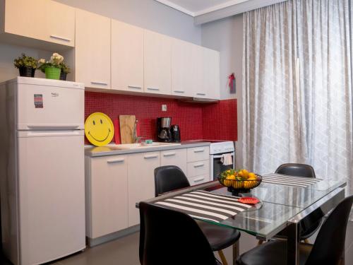 cocina con mesa y nevera blanca en Central Terrace Modern Apartment, en Tesalónica