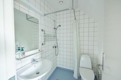 La salle de bains blanche est pourvue d'un lavabo et de toilettes. dans l'établissement Danhostel Odense City, à Odense