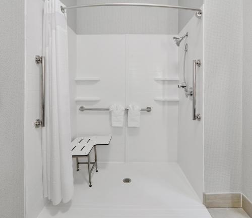a white bathroom with a table and a shower at Holiday Inn Express & Suites Dallas - Duncanville, an IHG Hotel in Duncanville