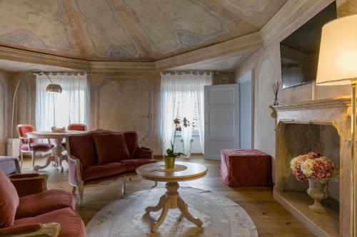 un salon avec un canapé et une cheminée dans l'établissement Rooms Castelvecchio - Palazzo Canossa, à Vérone