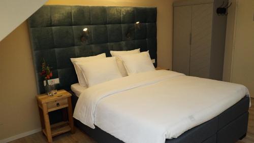 a bedroom with a large bed with a large headboard at Hotel Hoevevoorde in Rijswijk
