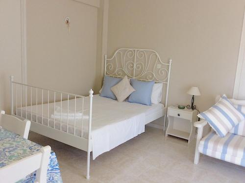 a bedroom with a white bed with blue pillows at Kefalonia apartments - Marias studios in Spartia in Spartia