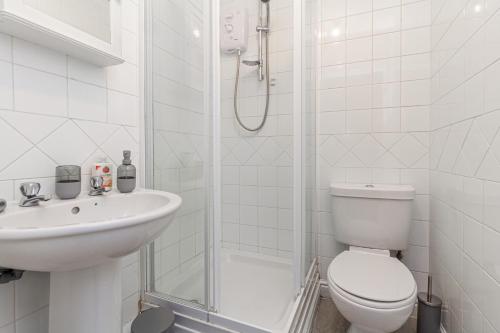 a white bathroom with a toilet and a sink at Guest Homes - New Street Apartment in Worcester