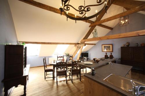 eine Küche und ein Esszimmer mit einem Tisch und einem Kronleuchter in der Unterkunft Gîtes d'Apothecarius entre Namur et Dinant in Fosses-La-Ville