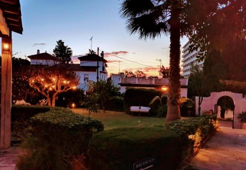 a house with a palm tree in a yard at Hostal Boutique Los Geranios del Pinar in Torremolinos