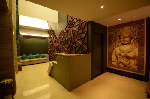 ein Zimmer mit einem Gemälde einer Statue an der Wand in der Unterkunft Hotel Ami Grace in Port Blair