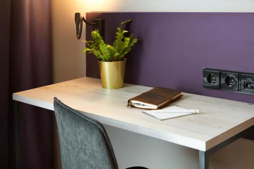a table with a plant and a purse on it at Holiday Inn - the niu, Air Frankfurt Messe by IHG in Frankfurt/Main