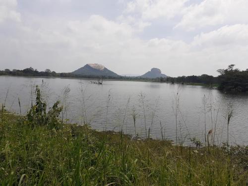 a large body of water with mountains in the background at Sigiriya Palace View in Sigiriya