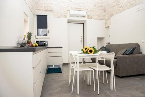 een keuken en een woonkamer met een tafel en stoelen bij Elaion Home in Ostuni