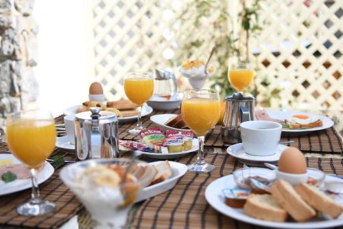 a table with plates of food and glasses of orange juice at Hotel Castillio in Analipsi