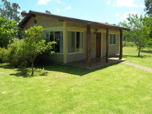 a small house in a field with a yard at La Posada del Mar in Miramar