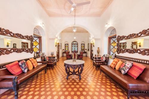 een woonkamer met banken en een tafel. bij SaffronStays Parsi Manor, Matheran in Matheran