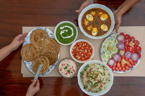 a table with plates of food and bowls of food at SaffronStays Parsi Manor, Matheran in Matheran