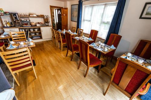 a dining room with wooden tables and chairs at Seawinds Bed and Breakfast in Killybegs