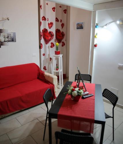a living room with a red couch and a table at Iluma in Ercolano