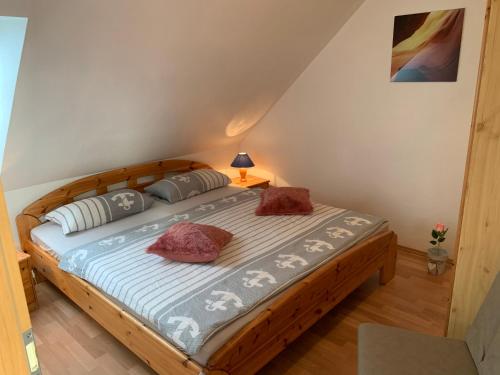 ノルトダイヒにあるFerienhaus Maria in Norddeichのベッドルーム1室(木製ベッド1台、枕2つ付)